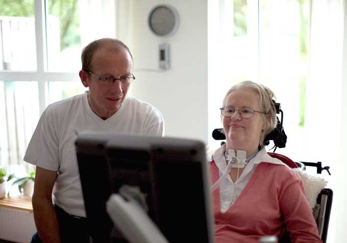 A handicapped woman sitting by computer screen